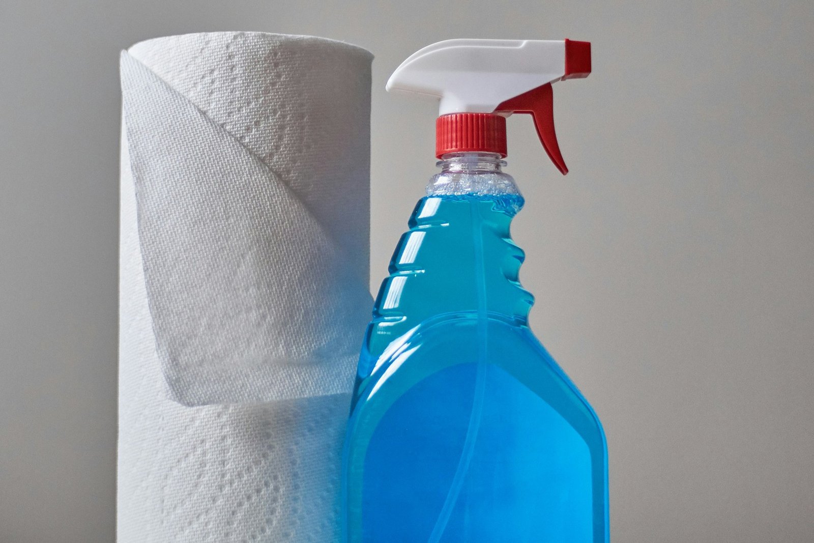 Sprühflasche neben einer Haarbürste auf dem Waschbecken