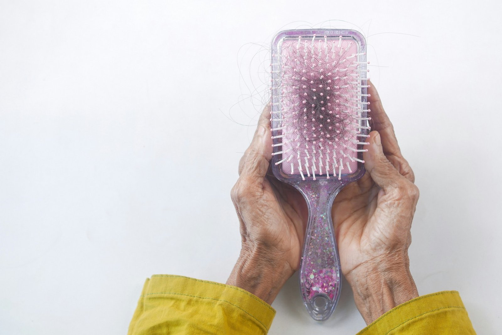 Fussel und Haare werden aus einer Haarbürste entfernt